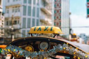 A yellow taxi sign is seen on a vehicle.